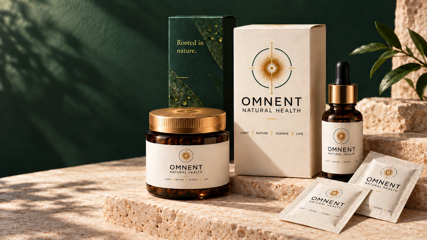 OMNENT packaging family in ivory, botanical green, gold and amber glass.